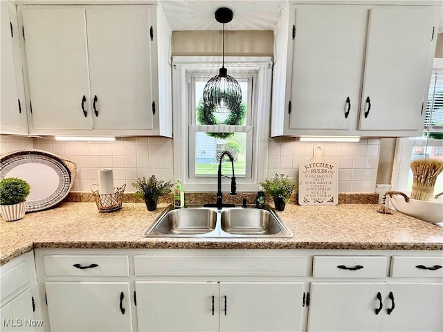 4812 Irma Ave, Youngstown, OH 44514 - kitchen with a sink, white cabinets, light countertops, and plenty of natural light