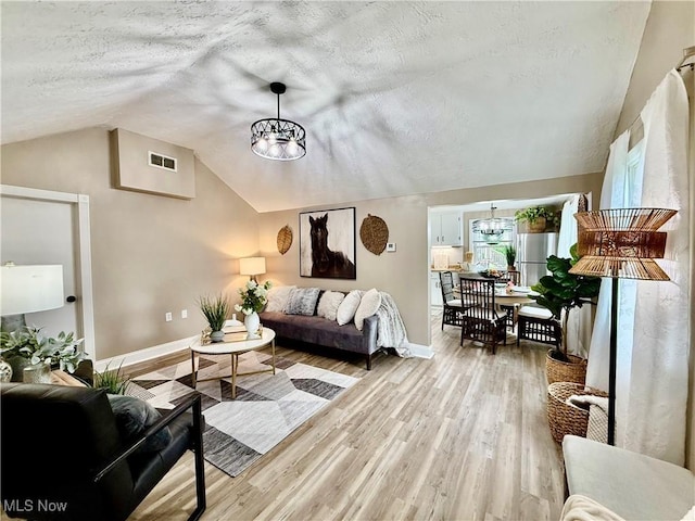 4812 Irma Ave, Youngstown, OH 44514 - living area featuring vaulted ceiling, a chandelier, a textured ceiling, baseboards, and light wood-style flooring
