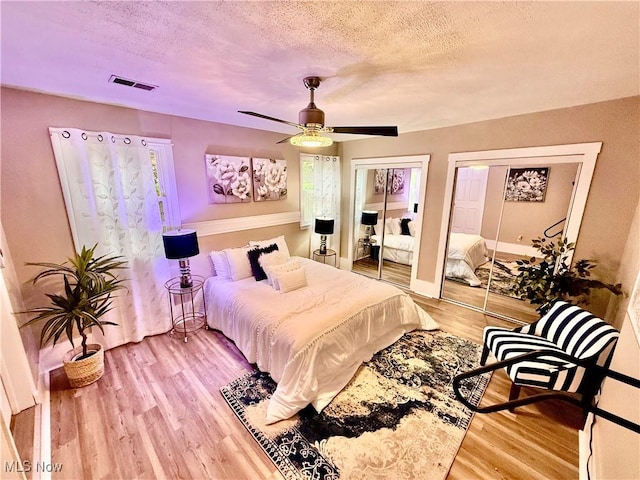 4812 Irma Ave, Youngstown, OH 44514 - bedroom featuring two closets, wood finished floors, a textured ceiling, and a ceiling fan