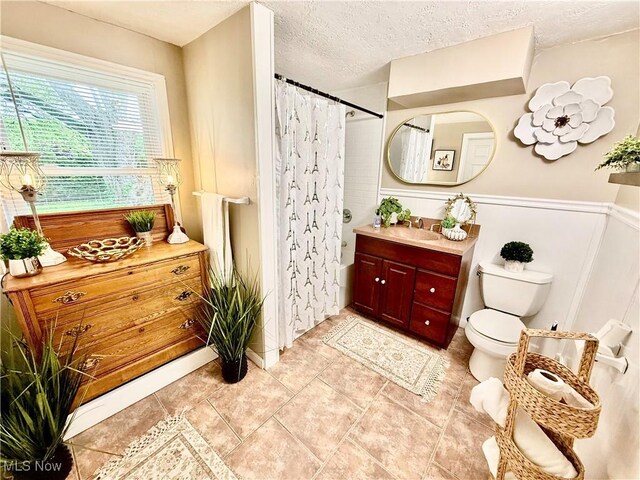 4812 Irma Ave, Youngstown, OH 44514 - bathroom with vanity, toilet, a shower with shower curtain, a textured ceiling, and wainscoting