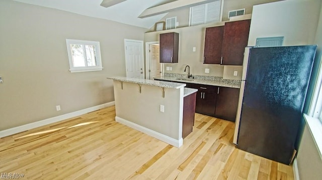 196 Vincent St, Chagrin Falls, OH 44022 - kitchen with freestanding refrigerator, light wood-type flooring, a breakfast bar area, a kitchen island, and a sink