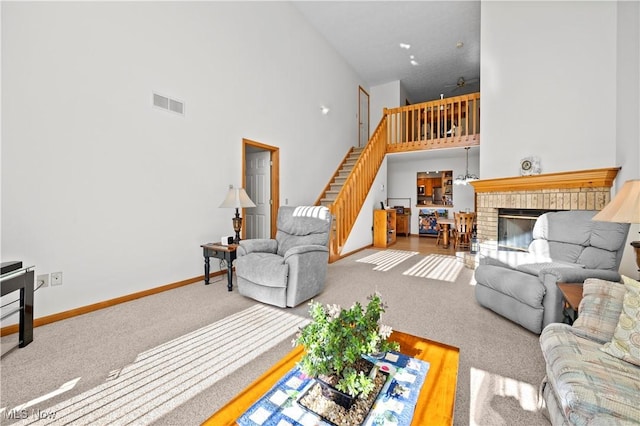 living area with a high ceiling, stairway, baseboards, carpet floors, and a fireplace