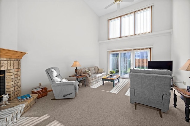 carpeted living room featuring high vaulted ceiling, plenty of natural light, a fireplace, and a ceiling fan