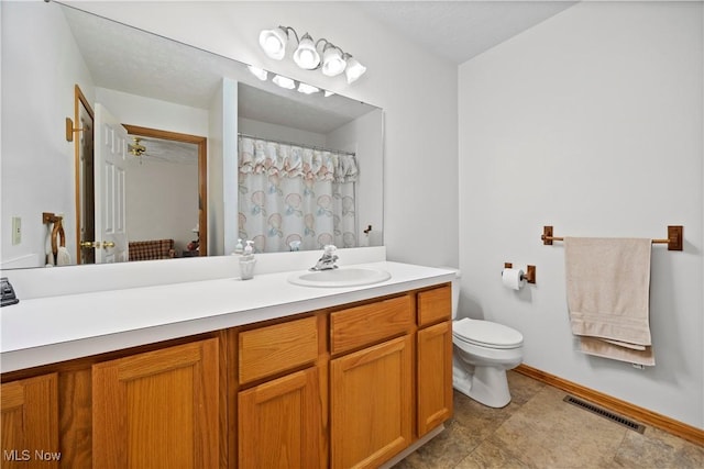 bathroom featuring toilet, baseboards, vanity, and a shower with shower curtain
