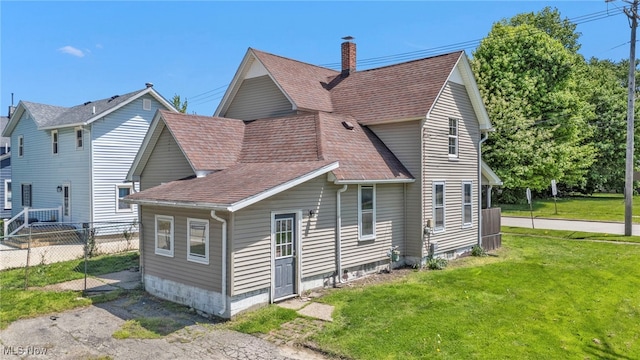563 Mill St, Conneaut, OH 44030 - rear view of property featuring a shingled roof and a chimney
