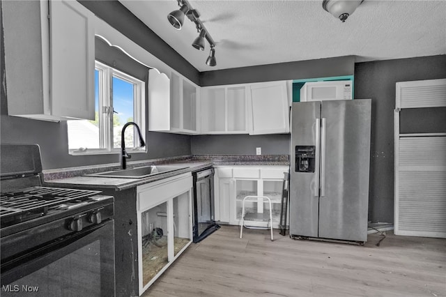 563 Mill St, Conneaut, OH 44030 - kitchen with black range with gas cooktop, stainless steel fridge with ice dispenser, a sink, white cabinetry, and dishwashing machine
