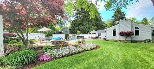 view of yard featuring a patio, a fire pit, and outdoor dining area