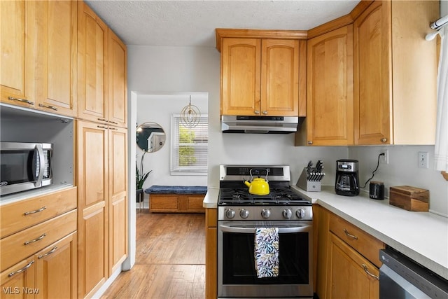 211 Harcourt Dr, Akron, OH 44313 - kitchen with stainless steel appliances, under cabinet range hood, light wood finished floors, light countertops, and a textured ceiling
