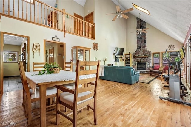2854 Wells Lock Rd, Elizabeth, WV 26143 - dining area with high vaulted ceiling, wood-type flooring, a ceiling fan, and a fireplace