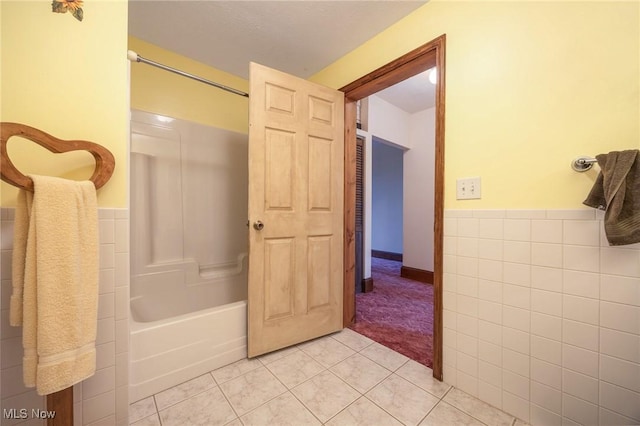 50504 State Route 556, Clarington, OH 43915 - bathroom featuring tile walls, tile patterned floors, a wainscoted wall, and bathing tub / shower combination