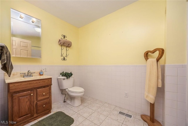50504 State Route 556, Clarington, OH 43915 - bathroom featuring tile walls, toilet, a wainscoted wall, vanity, and tile patterned floors