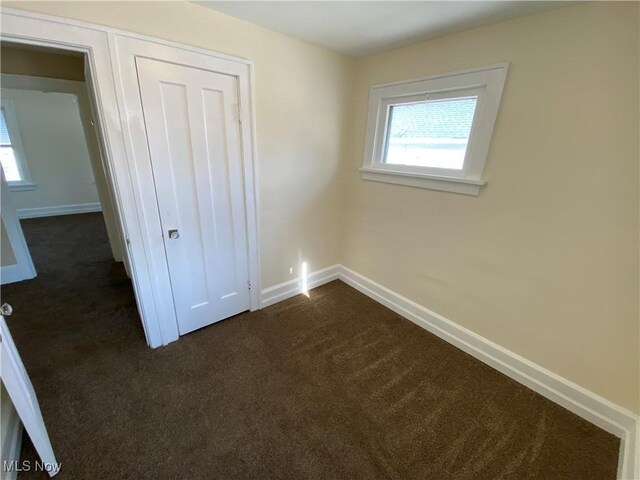 5161 Greenhurst Dr, Maple Heights, OH 44137 - unfurnished bedroom with dark carpet, baseboards, and a closet