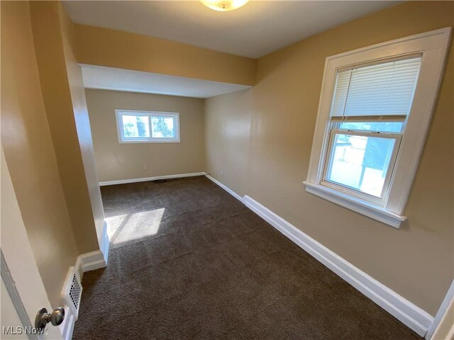 5161 Greenhurst Dr, Maple Heights, OH 44137 - spare room featuring dark colored carpet and baseboards