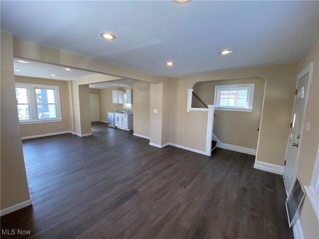 5161 Greenhurst Dr, Maple Heights, OH 44137 - unfurnished living room featuring dark wood-style flooring, stairway, baseboards, recessed lighting, and arched walkways