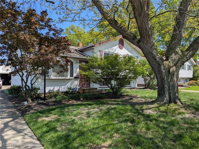 obstructed view of property with a front yard and a chimney