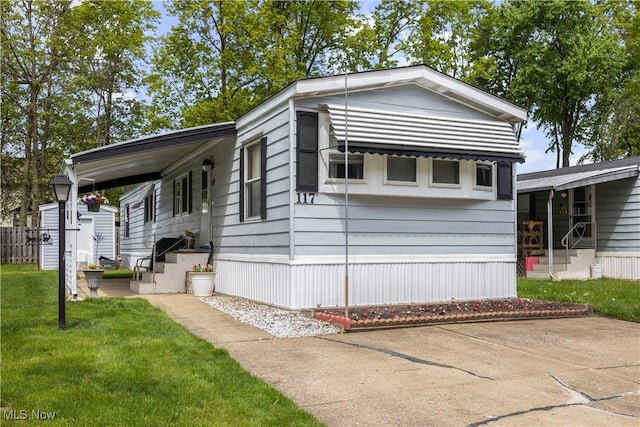 manufactured / mobile home featuring a front yard and entry steps