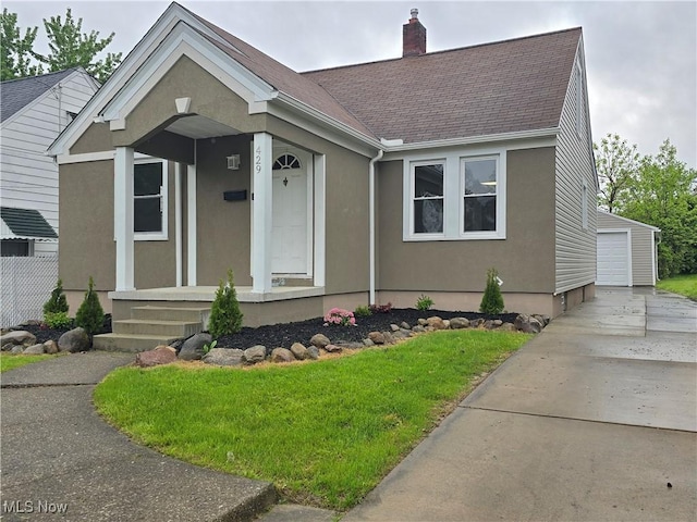 429 N Osborn Ave, Youngstown, OH 44509 - view of front of home featuring a chimney, a shingled roof, an outbuilding, a front lawn, and stucco siding