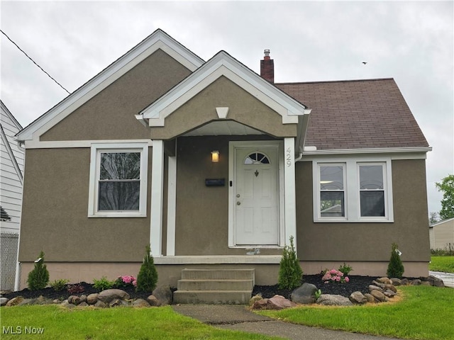 429 N Osborn Ave, Youngstown, OH 44509 - view of front facade with stucco siding, a chimney, and a shingled roof