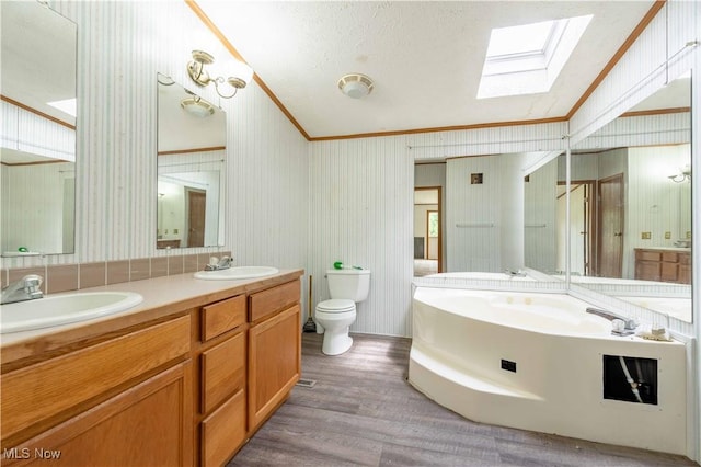 5240 Chalon Rd SW, Carrollton, OH 44615 - full bathroom featuring a skylight, ornamental molding, toilet, wood finished floors, and double vanity