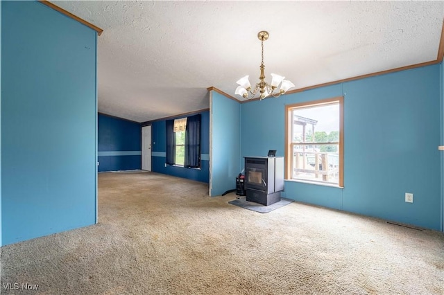 5240 Chalon Rd SW, Carrollton, OH 44615 - unfurnished living room with a wood stove, carpet floors, a chandelier, healthy amount of natural light, and a textured ceiling