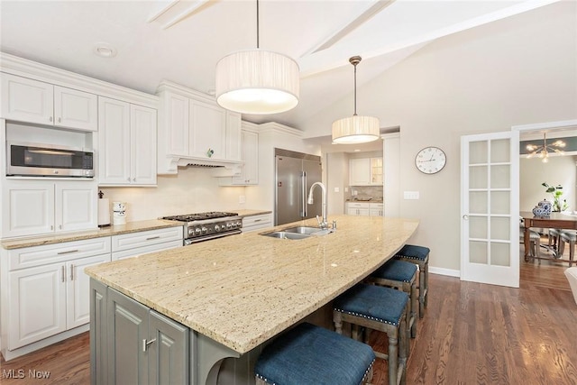 4168 Hadleigh Rd, University Heights, OH 44118 - kitchen featuring premium appliances, a sink, white cabinets, an island with sink, and a kitchen breakfast bar