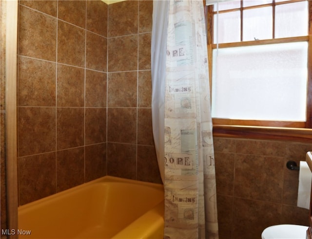 full bath featuring plenty of natural light, shower / tub combo with curtain, and toilet