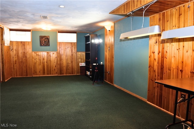 below grade area with wood walls, baseboards, and carpet