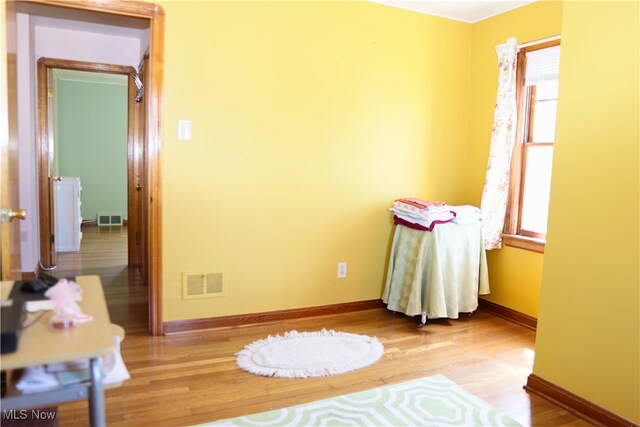 empty room featuring light wood-style floors, plenty of natural light, and baseboards