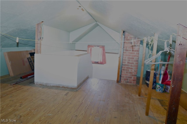 additional living space featuring hardwood / wood-style floors and lofted ceiling