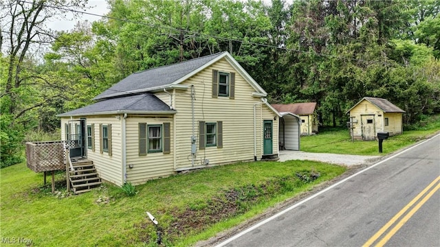 8055 Dolphin St SW, Bolivar, OH 44612 - view of front facade with a shed, an outbuilding, dirt driveway, a front lawn, and a deck