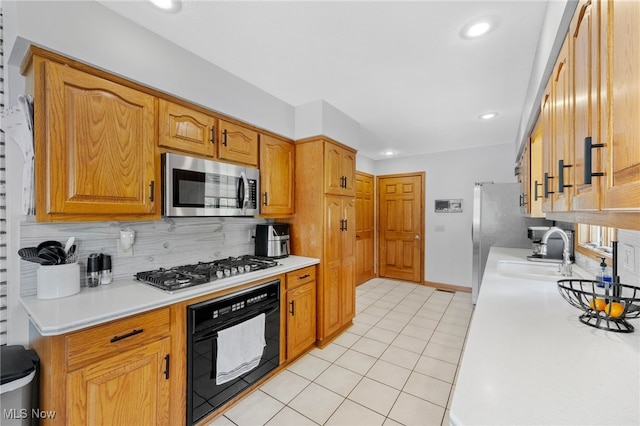 218 Tanglewood Dr, Dalton, OH 44618 - kitchen with stainless steel appliances, a sink, backsplash, light countertops, and light tile patterned floors