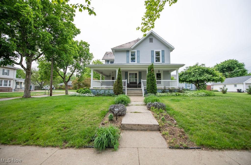 502 W Main St, Malvern, OH 44644 - country-style home featuring a porch and a front lawn