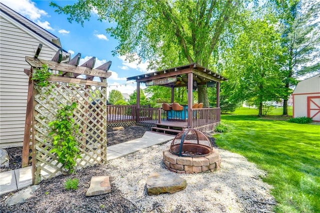 view of patio / terrace with an outdoor fire pit, a gazebo, a deck, and an outbuilding