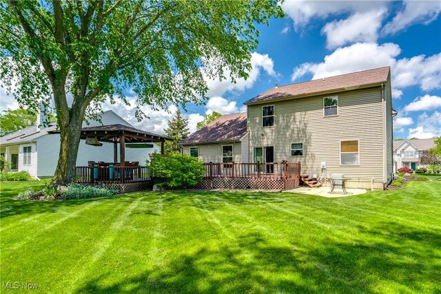 back of house featuring a gazebo, a deck, a lawn, and a patio area