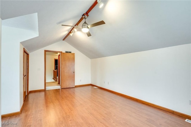 additional living space with ceiling fan, lofted ceiling, light wood-style flooring, and baseboards