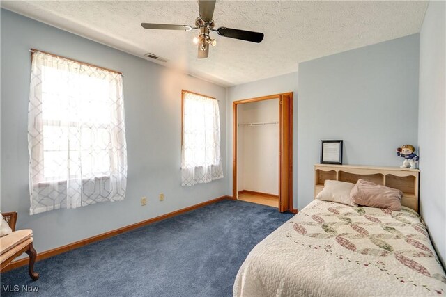 bedroom featuring carpet, a textured ceiling, baseboards, ceiling fan, and a closet