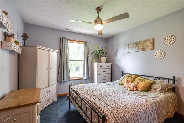 bedroom featuring dark colored carpet, ceiling fan, a textured ceiling, and baseboards