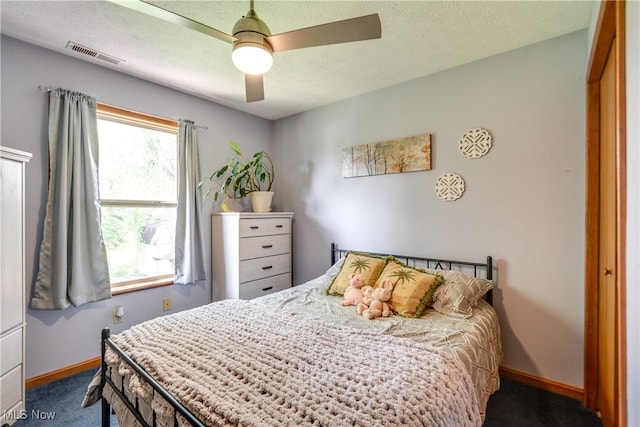 carpeted bedroom featuring baseboards, a ceiling fan, and a textured ceiling