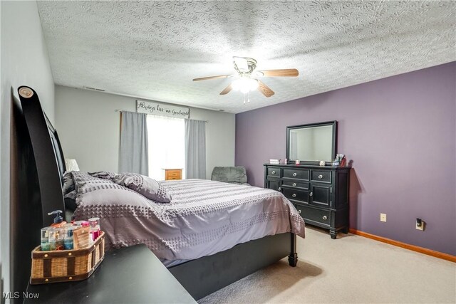bedroom with light carpet, a ceiling fan, a textured ceiling, and baseboards