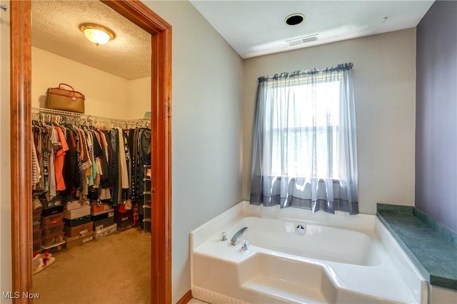 full bathroom with a garden tub and a spacious closet
