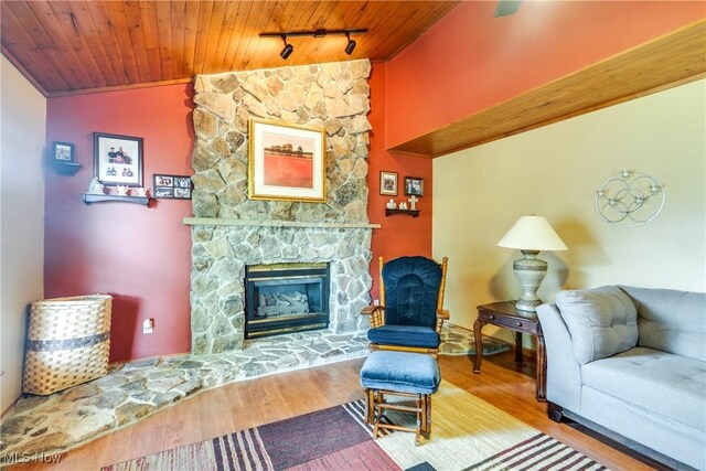 living room featuring wood ceiling, a fireplace, wood finished floors, crown molding, and lofted ceiling