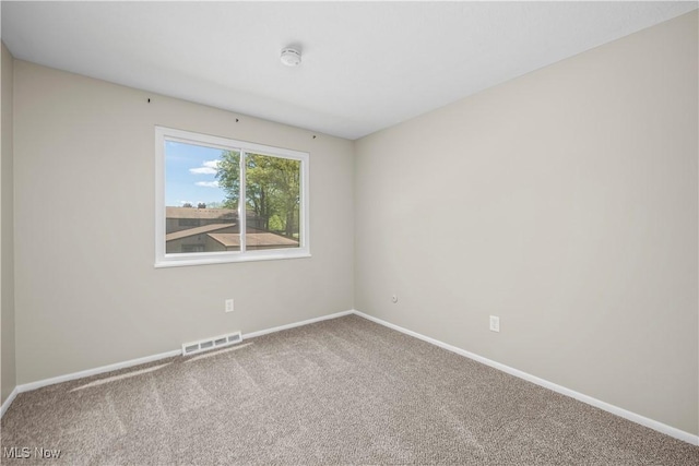 empty room with carpet flooring, baseboards, and a smoke detector