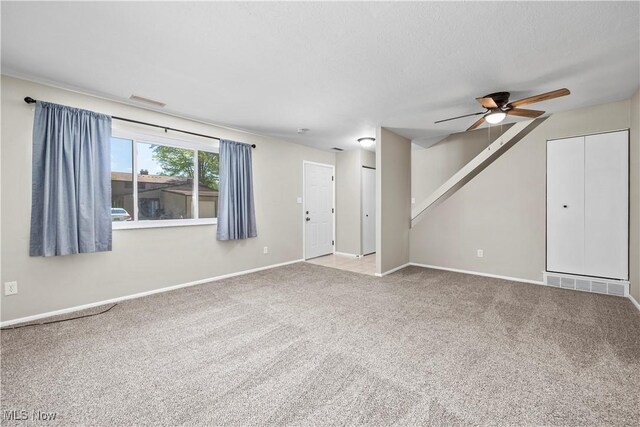 unfurnished living room featuring ceiling fan, carpet flooring, and baseboards