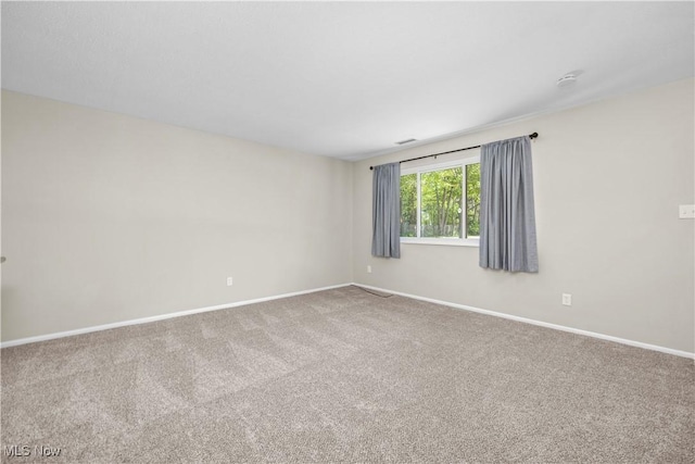 carpeted spare room featuring baseboards