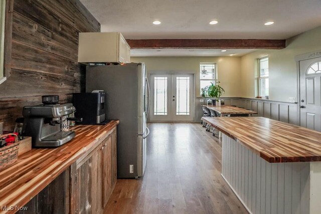 7841 State St NE, Louisville, OH 44641 - kitchen featuring wooden counters, freestanding refrigerator, beam ceiling, wood finished floors, and a wainscoted wall