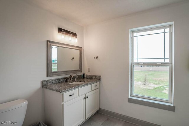 7841 State St NE, Louisville, OH 44641 - bathroom featuring plenty of natural light, vanity, toilet, and baseboards