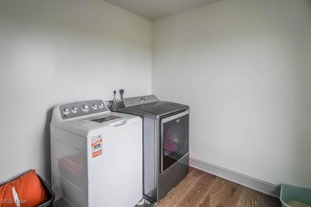 7841 State St NE, Louisville, OH 44641 - clothes washing area featuring separate washer and dryer and wood finished floors