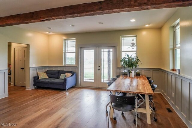 7841 State St NE, Louisville, OH 44641 - dining space featuring french doors, healthy amount of natural light, wood finished floors, a wainscoted wall, and beam ceiling