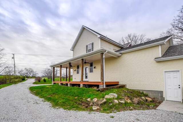 7841 State St NE, Louisville, OH 44641 - view of side of home featuring ceiling fan and covered porch