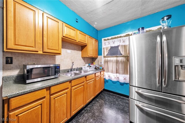 3741 E 146th St, Cleveland, OH 44120 - kitchen featuring stainless steel appliances, a sink, decorative backsplash, and a textured ceiling